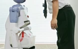 Le robot de service à la personne "Enon" développé par Fujitsu communique avec un ingénieur avant de transporter un paquet, à Tokyo le 13 septembre 2005