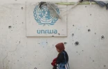 Le logo de l'Unrwa sur un mur criblé d'impacts dans un camp pour personnes déplacées à Rafah, dans le sud de la bande de GAza, le 28 mai 2024