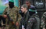 Des combattants palestiniens du Hamas escortent l'otage israélien Eli Sharabi sur un podium avant de le remettre à une équipe de la Croix-Rouge à Deir el-Balah, dans le centre de Gaza, le 8 février 2025