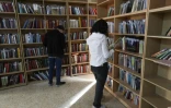 Des membres du Centre des arts et de la culture du Kurdistan (KCAC) examinent des livres anciens dont ils feront une copie numérique à la bibliothèque de Dohouk, le 13 février 2024, dans la région du Kurdistan autonome, dans le nord de l'Irak dans une bibliothèque à Dohouk, dans la région du Kurdistan autonome, dans le nord de l'Irak, le 13 février 2024