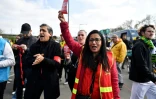 Une militante de la CGT brandit un "carton rouge à la retraite à 64 ans" à la sortie du métro à Saint-Denis, près de Paris, le 29 avril 2023