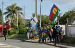 Des manifestants avec des drapeaux kanak sur le parcours du cortège du président de la République Emmanuel Macron à Nouméa, en Nouvelle-Calédonie, le 23 mai 2024