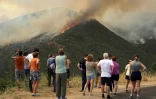 Des habitants observent un incendie de forêt à Castrillo de Cabrera, dans le nord-ouest de l'Espagne, le 16 août 2025