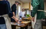 Mari Fujii (c) montre comment préparer une soupe de légumes aux participants d'un cours intensif de cuisine bouddhiste végétarienne "shojin", le 15 avril 2023 à Kamakura, au Japon