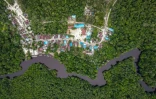 Vue aérienne du village de Humbang Raya le long d'une rivière et au coeur de la forêt dans la régence de Kapuas du Kalimantan central, le 11 février 2026 en Indonésie