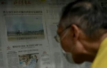 Homme lisant un journal rapportant les manoeuvres militaires chinoises à proximité de Taïwan, le 8 août 2022 à Pékin