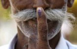 Un électeur montre son doigt marqué à l'encre après avoir déposé son bulletin dans un bureau de vote dans le village de Gola à Banaskantha, en Inde, le 7 mai 2024