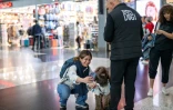Une voyageuse fait un selfie avec Kuki, un chien de thérapie pour réconforter les passagers stressés avant leur embarquement à l'aéroport d'Istanbul, le 3 mai 2024 en Turquie