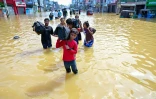 Des habitants emportent leurs biens dans une rue inondée de la banlieue de Colombo, la capitale du Sri Lanka, le 30 novembre 2025
