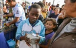 Des migrants vénézuéliens qui ont fui la crise économique dans leur pays reçoivent de l'aide et de la nourriture à Tumbes, au Pérou, à la frontière avec l'Equateur, le 23 août 2018