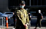 Un membre des forces armées australiennes surveille l'entrée d'un centre de vaccination à Sydney, le 18 août 2021