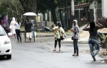 Une femme portant un enfant destiné à faire du co-voiturage à Jakarta, le 31 mars 2016