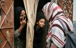Une agente de santé parle à une femme et sa fille, lors d'une campagne de vaccination porte-à-porte contre le virus du papillome humain (VPH) responsable du cancer du col de l'utérus, le 24 septembre 2025 à Karachi, au Pakistan