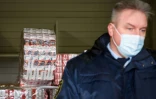 Taivo Hanzens, chef adjoint des douanes à Paternieki montre des boites de cigarettes de contrebande, stockées à la frontière entre le Belarus et la Lettonie, le 8 février 2021