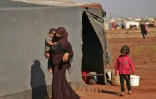 Des Syriens devant une tente dans un camp de déplacés dans la province d'Idleb, le 5 septembre 2018 