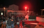 Des manifestants cagoulés ou portant des capuches lancent divers projectiles -pierres, planches, gros pétards - en direction des gendarmes mobiles venus de Bastia, le 15 février 2016 à Corte