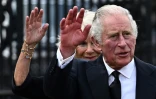 Le roi Charles III et la reine consort Camilla saluent la foule à leur arrivée au palais de Buckingham, le 9 septembre 2022 à Londres