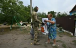Une électrice glisse son bulletin dans une urne mobile à l'occasion d'un vote anticipée pour les législatives russes dans la région occupée de Donetsk, dans l'est de l'Ukraine, le 15 septembre 2026
