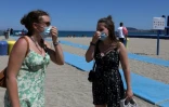 Deux femmes remettent leur masque en revenant de la plage - même s'il n'est pas obligatoire - à Argeles-sur-Mer (sud de la France), le 17 juillet 2021