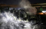 Les restes calcinés d'un véhicule de la Force de l'ONU au Liban (Finul), incendié par des manifestants, sur la route menant à l'aéroport international de Beyrouth, le 14 février 2025