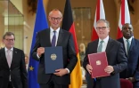 Le Premier ministre britannique Keir Starmer (2e d) et le chancelier allemand Friedrich Merz (e g) lors d'une cérémonie de signature d'un traité de coopération bilatérale à Londres, le 17 juillet 2025