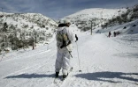 Un militaire israélien observe les skieurs sur une piste du mont Hermon, sur le Golan occupé par l'Etat hébreu, le 21 janvier 2016