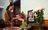Une proche de Bui Thi Nhung, dont sa famille craint qu'elle soit un des 39 migrants trouvés morts dans un camion en Grande-Bretagne, devant un autel improvisé dans la maison de la jeune femme, dans le centre du Vietnam, le 26 octobre 2019