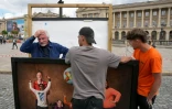 Le photographe Yann Arthus-Bertrand (G) avec des volontaires ayant aidé à la remise en place de l'exposition photos en plein air sur la place de la Concorde à Paris, le 7 mai 2026