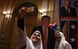 Des écolières malaisiennes posent pour un selfie devant un portrait de Donald Trump, à Kuala Lumpur le 9 novembre 2016