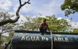 Un camion-citerne remplit d'eau potable en attente d'être distribuée après une panne d'électricité massive, le 13 mùars 2019 à Caracas, au Venezuela