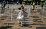 Des enfants jouent dans une fontaine devant un centre commercial de Pékin, le 1er juin 2021 en Chine