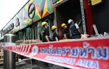 Des membres de la police scientifique inspectent les décombres calciné du bar-restaurant Rong Beer Na Lat Phrao, le 13 juillet 2026 à Bangkok, en Thaïlande