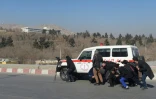 Sur ce cliché pris en janvier 2018 par le photographe de l'AFP Shah Marai, tué lundi dans un attentat à Kaboul, des journalistes s'abritent derrière une ambulance durant des combats dans la capitale afghane