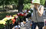 Femme devant le mémorial fait de fleurs et de peluches, le 29 juin 2022, devant le centre commercial de Krementchouk bombardé deux jours plus tôt