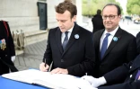 Les présidents sortant et élu François Hollande (D) et Emmanuel Macron signent le livre d'or le 8 mai 2017 sous l'Arc de Triomphe place de l?Étoile
