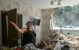 Natalia, 47 ans, se tient parmi les débris de sa maison, lourdement endommagée à la suite de récentes frappes dans un village proche de la frontière russe dans la région de Sumy, en Ukraine, le 16 août 2024