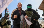 L'otage israélo-argentin Yair Horn est escorté par des combattants du Hamas avant sa remise au Comité international de la Croix Rouge, le 15 février 2025 à Khan Younes, dans la bande de Gaza