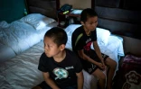 Deux jeunes garçons attendent dans leur chambre d'hôtel avant de participer à un entraînement d'arts martiaux mixte (MMA) à Chengdu en Chine, le 2 juin 2017