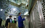 Un Iranien désinfecte le sanctuaire de Fatima Masoumeh à Qom, dans le centre de l'Iran, le 25 février 2020