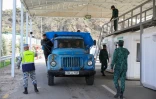 Des soldats azerbaïdjanais contrôlent un véhicule au poste de Latchine où des habitants du Nagorny Karabakh attendent dans leurs voitures de quitter leur région pour passer en Arménie, le 26 septembre 2023.