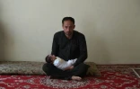 Akram, 40 ans, dont la femme a été tuée dans l'attaque de la maternité de Kaboul, tient sa fille Maryam, le 22 mai 2020