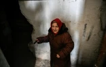 Une femme âgée descend dans la cave de son immeuble à la lueur d'une lampe torche pour se protéger des bombardements à Chtchastian près de Lougansk, en Ukraine, le 22 février 2022