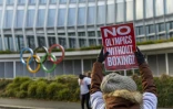 Une femme brandit une pancarte contre la suppression de la boxe au programme des JO, le 5 décembre 2022 devant le siège du Comité international olympique (CIO), le 5 décembre 2022 à Lausanne