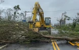 Image tirée d'une vidéo de l'AFPTV d'une pelleteuse dégageant des arbres tombés en travers d'une route après le passage du typhon Haikui, le 4 septembre 2023 à Taïwan