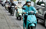 Phung Khac Trung, chauffeur de moto taxi, sur son scooter électrique, le 5 novembre 2024 à Hanoï, au Vietnam