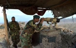 Le commandant de l'armée à Kajaki, Dost Nazar Andarabi, surveille à la jumelle les territoires talibans, le 23 mars 2021 à Kajaki, dans la province du Helmand, en Afghanistan