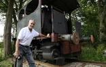 L'Américain Grégory Marshall devant une  locomotive à vapeur, dans l'ancienne gare de Dracy-Saint-Loup, le 11 juillet 2017 en Saône-et-Loire
