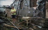 Une femme dans les décombres de sa maison le 16 août 2015 à Zolote, à l'ouest de Lougansk