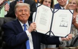 Le président américain Donald Trump montre la signature du le "Secure America Act", dansle Bureau ovale de la Maison Blanche, le 10 juin 2026 à Washington