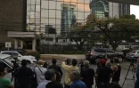 Des journalistes attendent à l'extérieur du bâtiment perquisitionné, le 12 avril 2016 à Panama